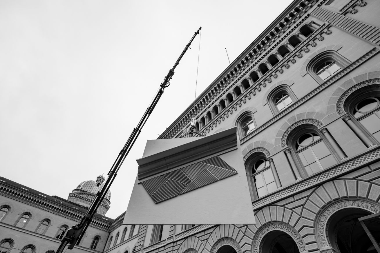 Una gru solleva il modello di prova sul tetto del Federal Palace West.